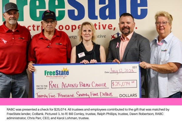 group posing with big check