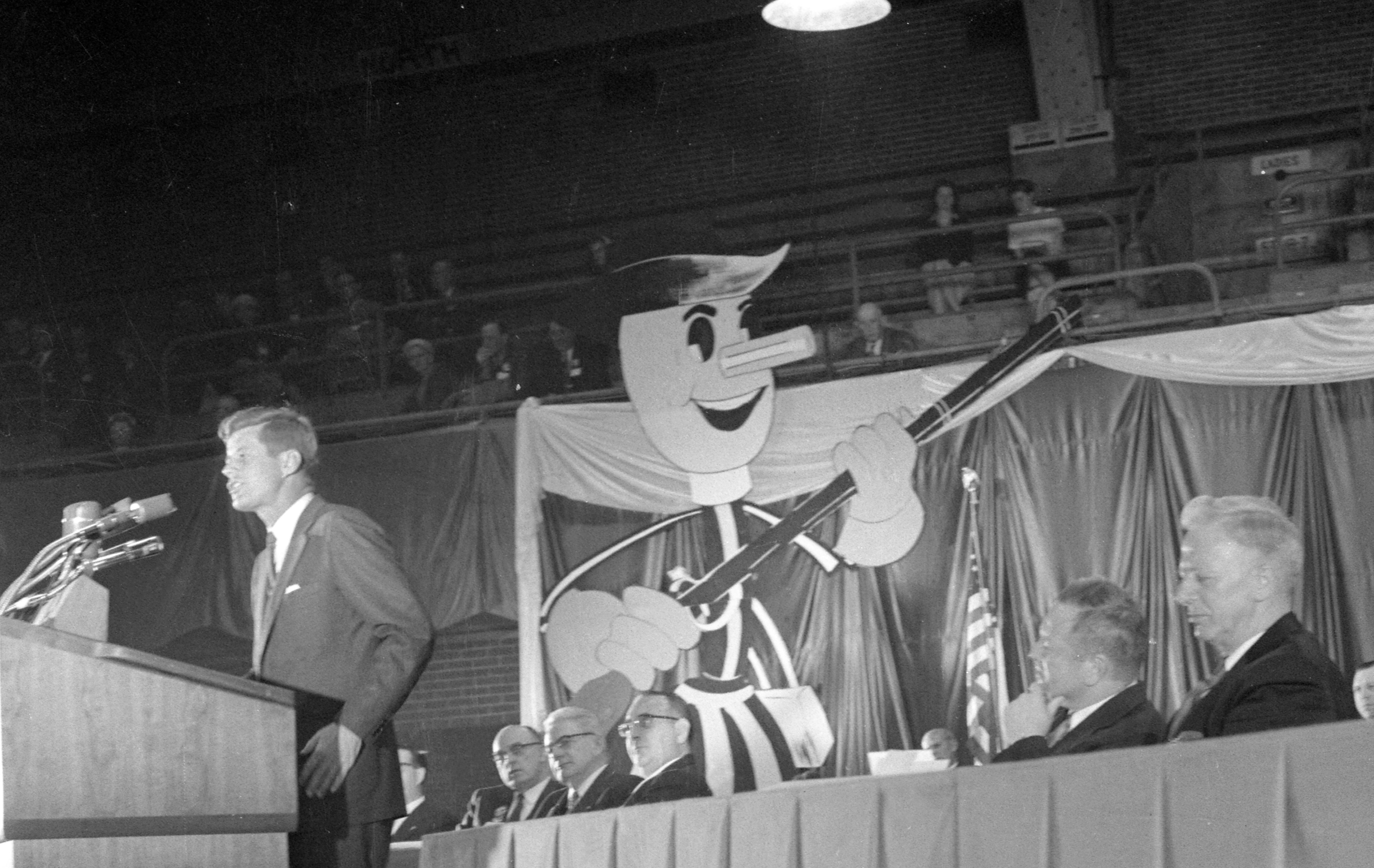 In 1959, Willie Wiredhand appeared on stage behind then Senator John F. Kennedy at an NRECA event in Washington, D.C. Dressed as a minuteman, Willie was promoting the “Minutemen for Rural Electrification” campaign.